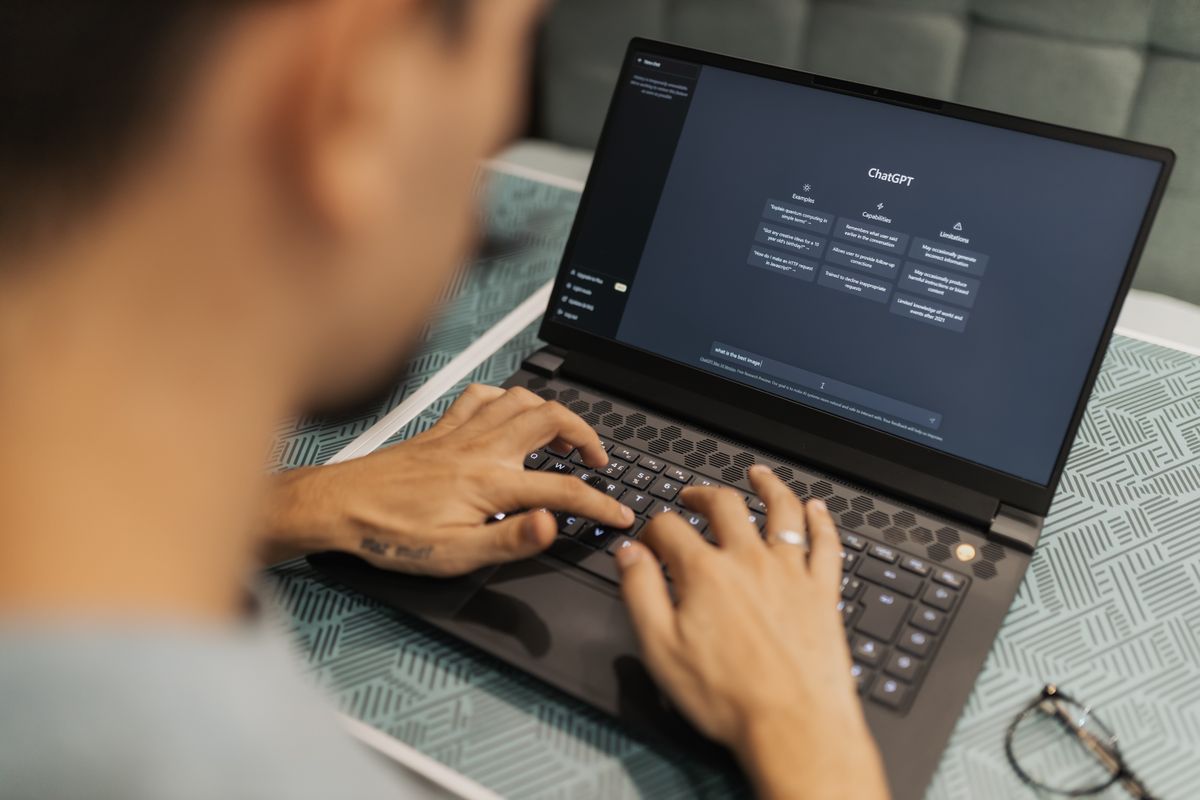 A person working on a laptop at a desk, illustrating the practical workflow of using AI assistants for data analysis