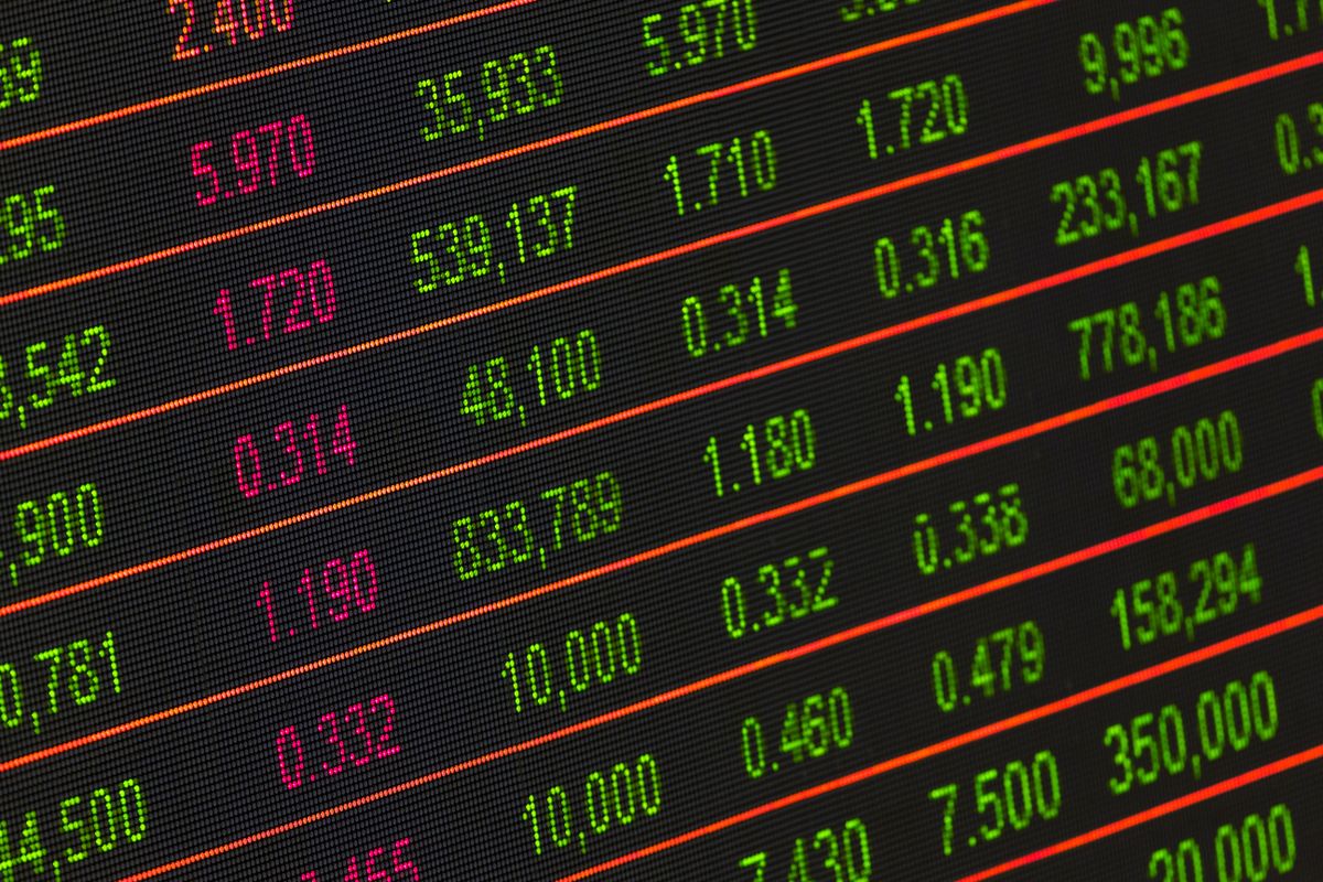 A close-up of a digital ticker board with green and red numbers and orange divider lines — a vivid example of color-coded data that mirrors conditional formatting principles
