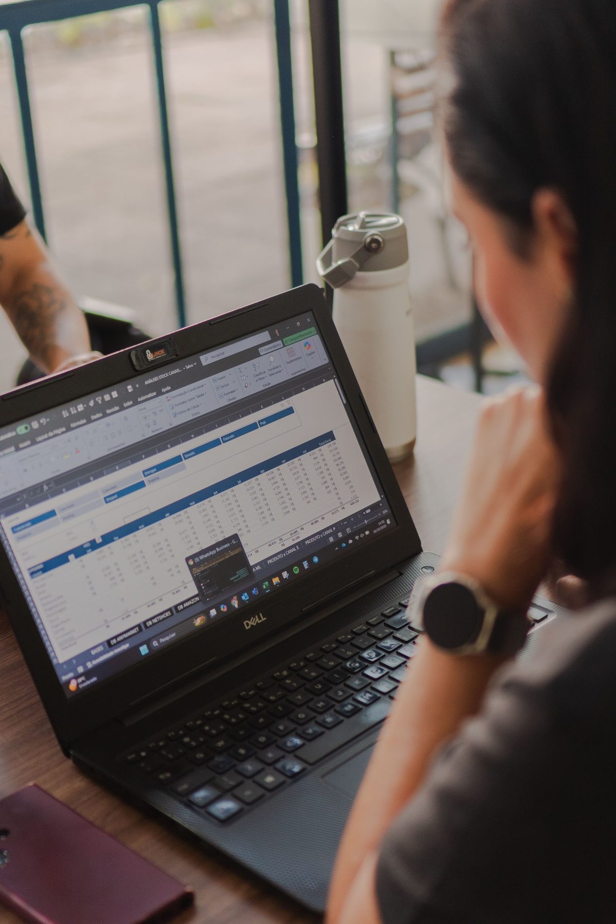 A person analyzing data and charts on a laptop screen in a bright workspace, showing the kind of spreadsheet and reporting work this decision guide is about